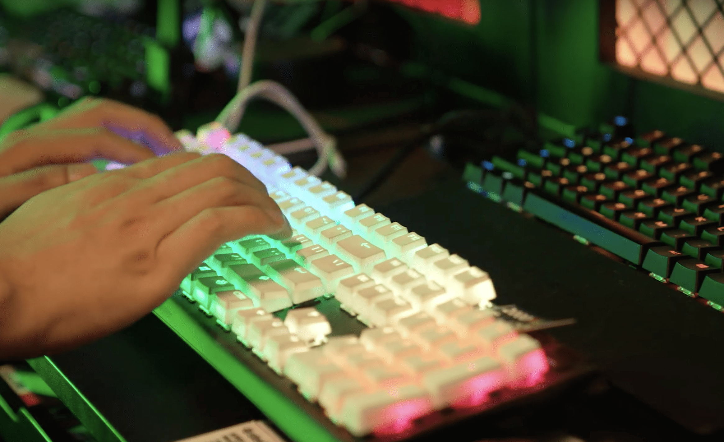 Hands typing on a colourful keyboard