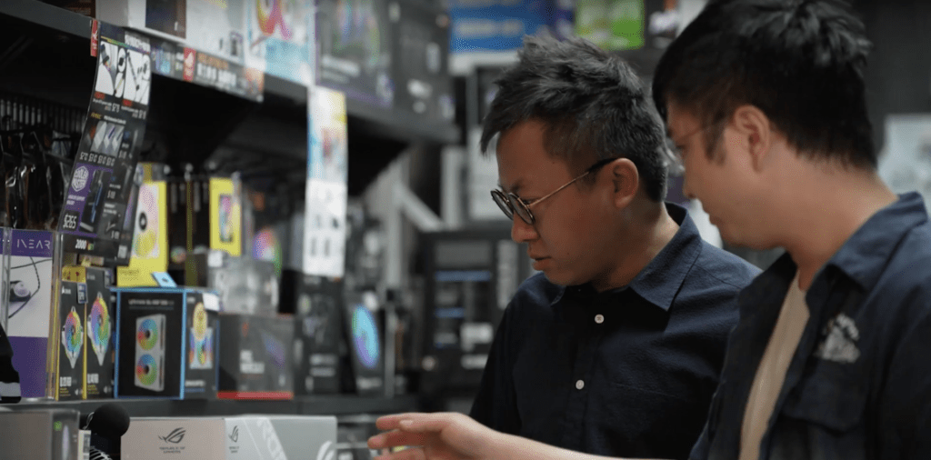 Two men checking on some components of the electronic devices.